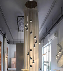  Sleek modern LED pendant lights hanging in a contemporary  high ceiling living room setting . Golden Atelier 3