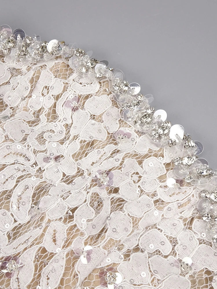 Close-up of lace fabric with beads on a gray background