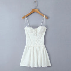 White lace dress on a wooden hanger against a gray background