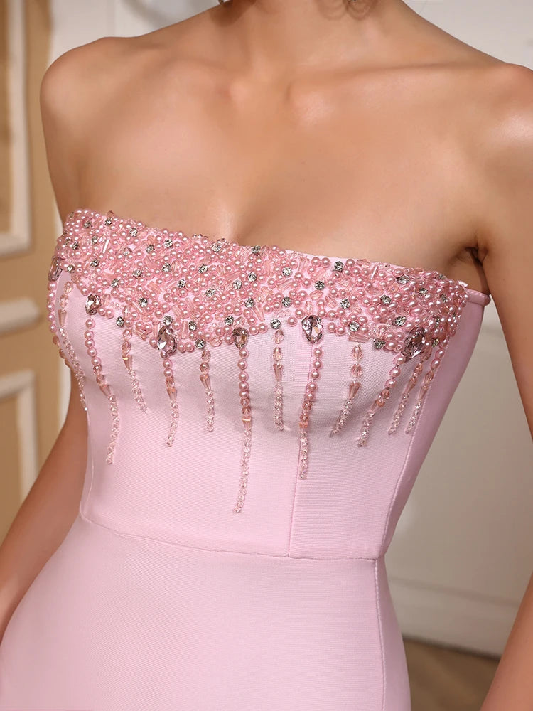 Pink strapless dress with beaded details on a neutral background