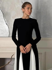 A woman wearing a black pleated patchwork maxi dress with long sleeves, showcasing its unique design. Golden Atelier 3