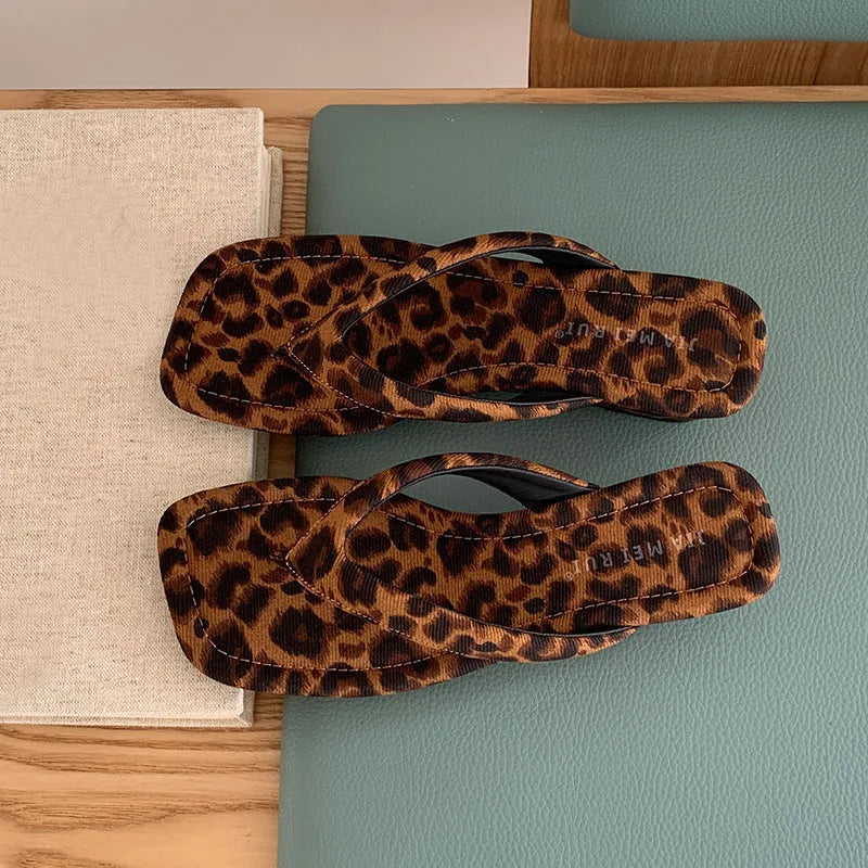 Pair of leopard print wedge flip flops