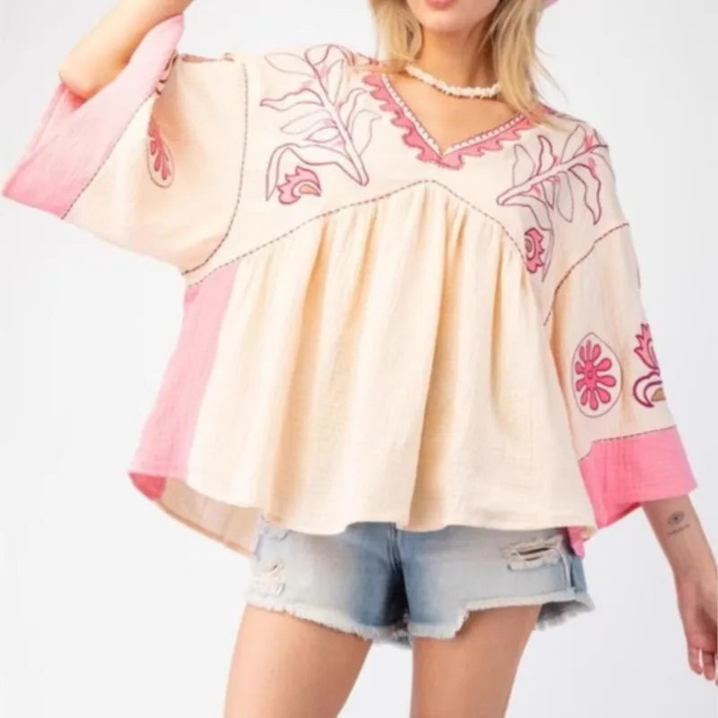 Embroidered V-neck flare sleeve top in cream and pink.