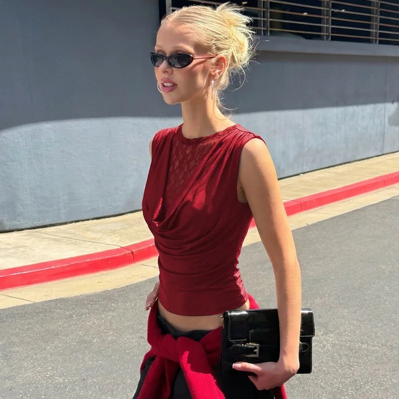 Woman in a red outfit holding a black clutch on a street.