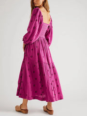 Woman wearing a pink dress with black patterns on a white background
