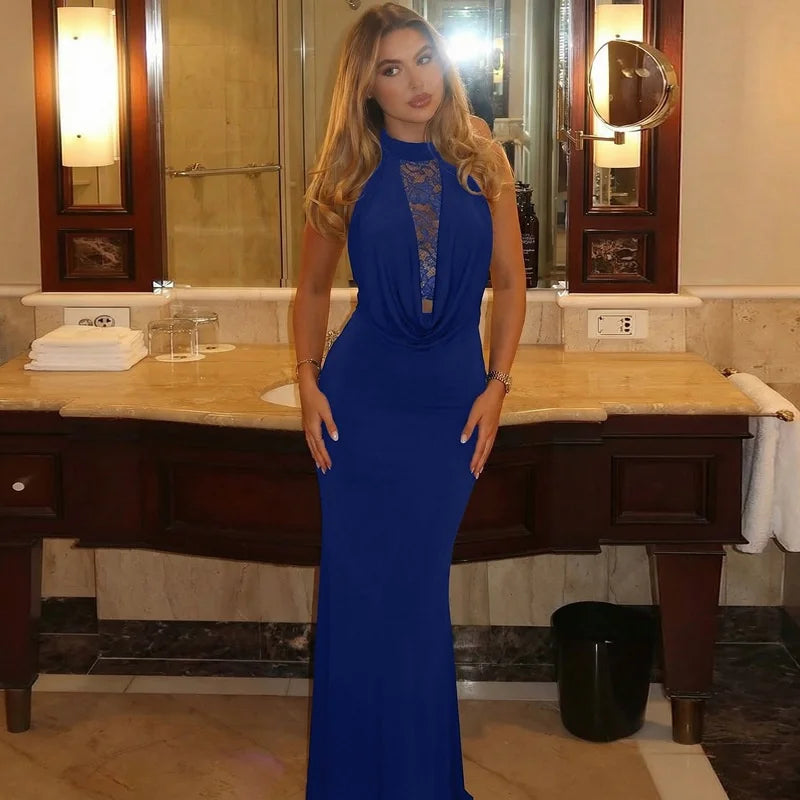 Woman in a blue dress standing in a bathroom.