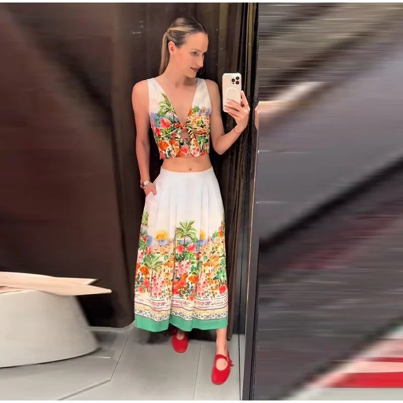 Woman in floral print V-neck sleeveless crop top and floral print pleated A-line midi skirt.