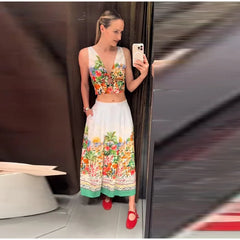 Woman in floral print V-neck sleeveless crop top and floral print pleated A-line midi skirt.