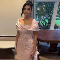 A model wearing the baby pink off-the-shoulder evening gown, showcasing its flattering silhouette and flowing skirt. Golden Atelier 2