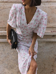 Woman wearing ankle-length white floral summer dress with V-neck and short sleeves