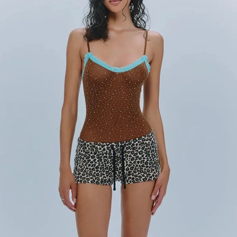 Woman wearing a brown top with blue trim and leopard print shorts on a light gray background