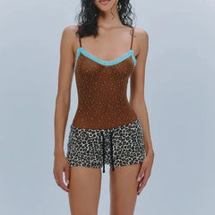 Woman wearing a brown top with blue trim and leopard print shorts on a light gray background