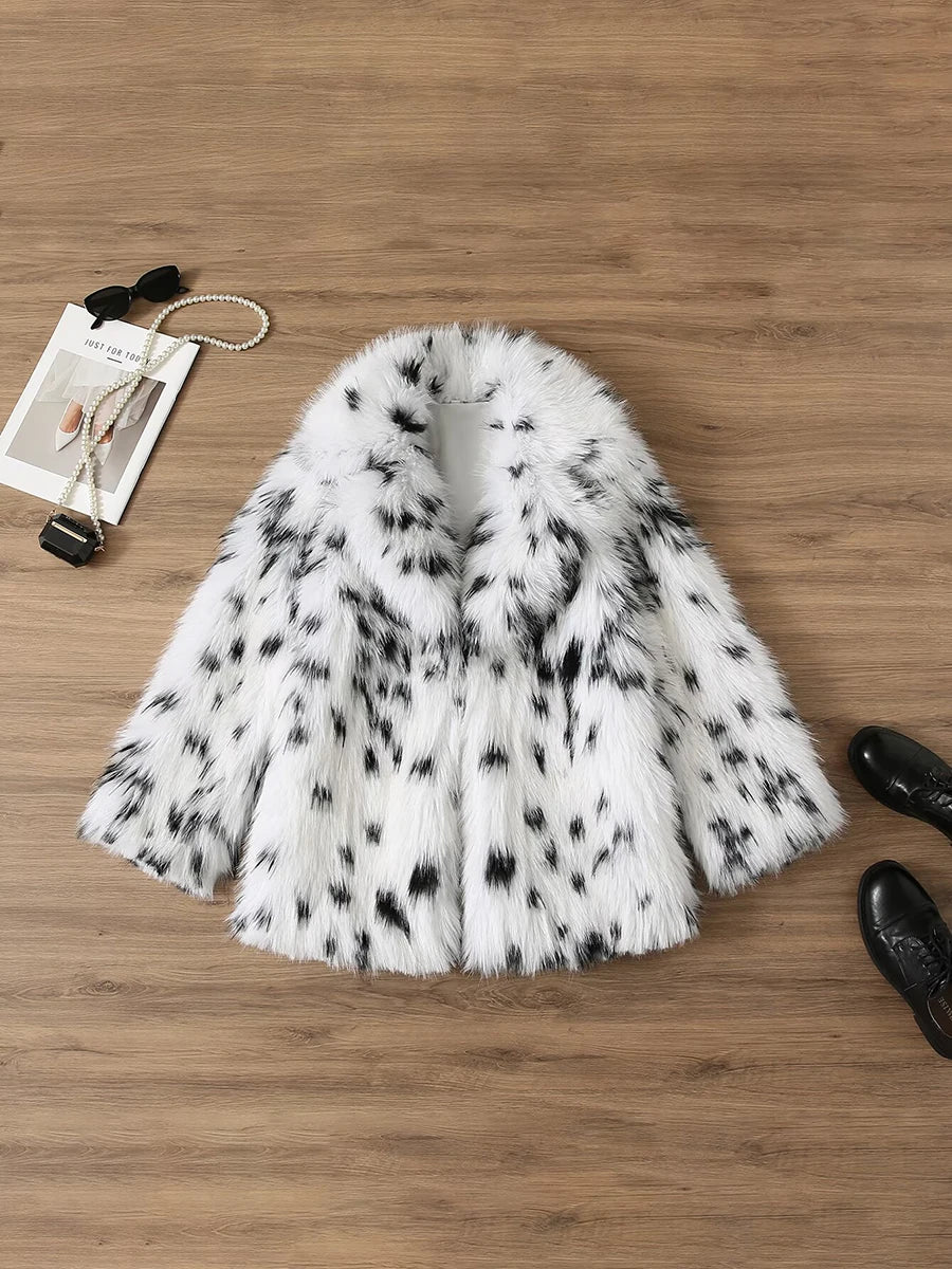 White fur coat with black spots on a wooden surface
