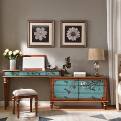 Hand-painted French vanity table with matching stool in a floral-themed bedroom