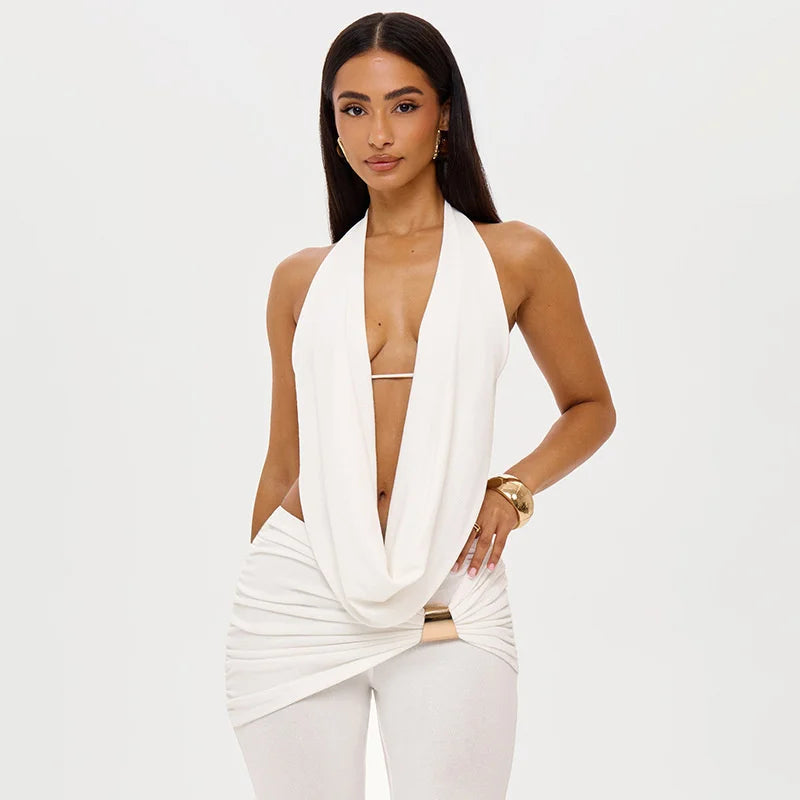 Woman wearing a white halter top and pants on a plain background