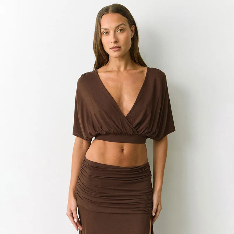 Woman wearing a brown dress against a plain background