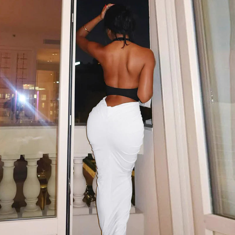 Person wearing a black top and white pants standing in front of a mirror.