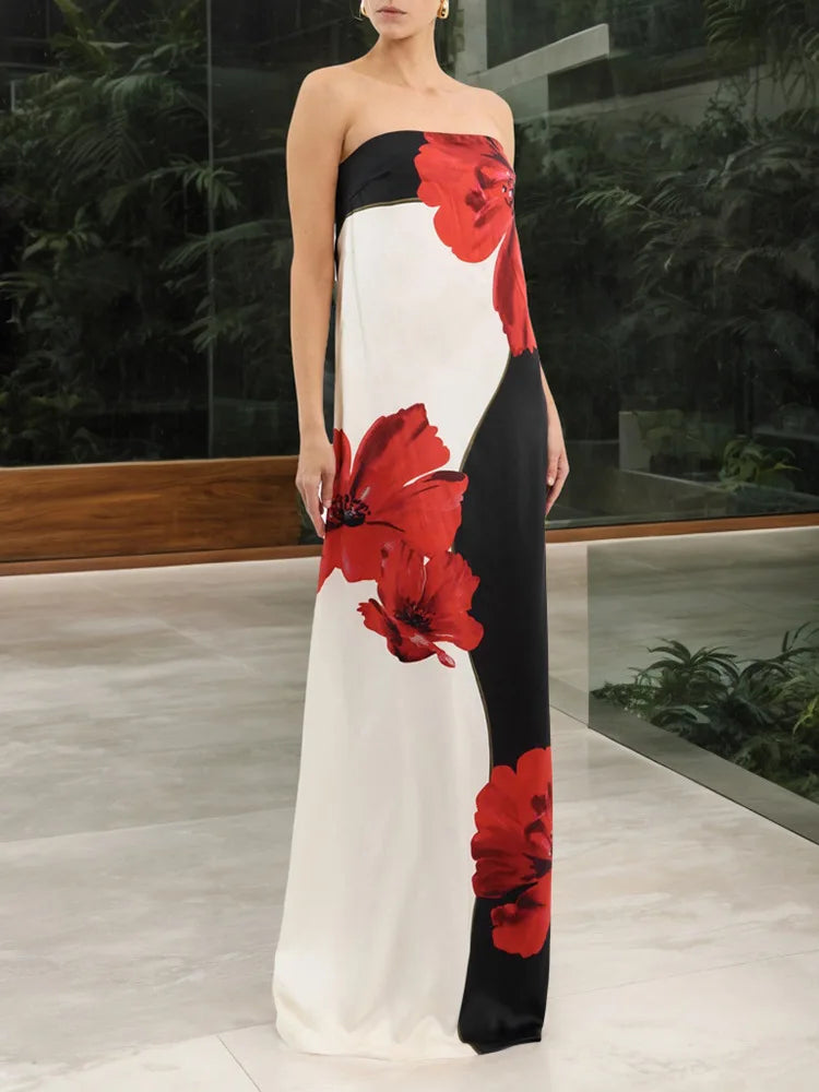 Woman wearing a strapless dress with red floral patterns in a modern indoor setting