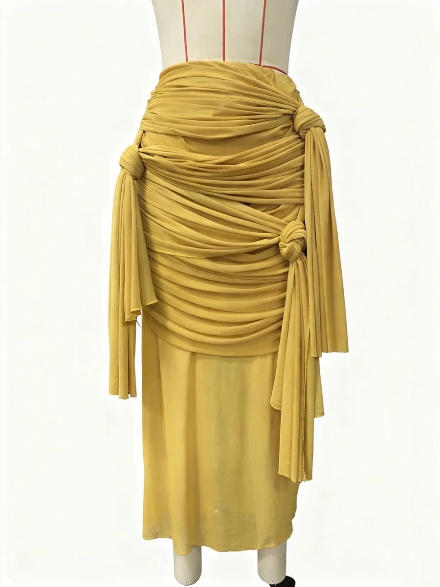Mustard yellow draped skirt on a mannequin against a white background