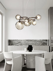 Modern minimalist glass chandelier with a Nordic design, illuminating a stylish living room. Golden Atelier 2