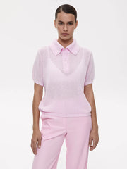 Person wearing a light pink polo shirt and pants on a white background