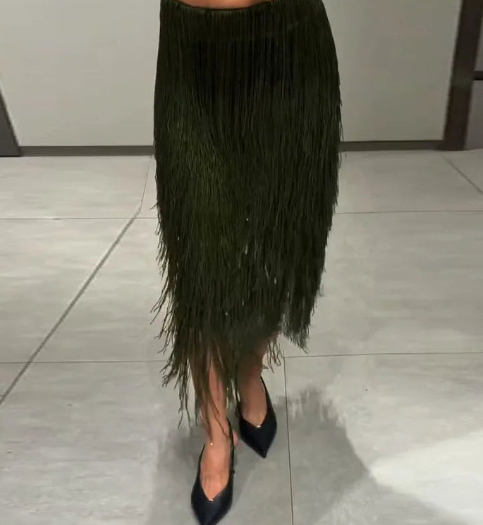 Person wearing a black feathered skirt and black shoes on a tiled floor.