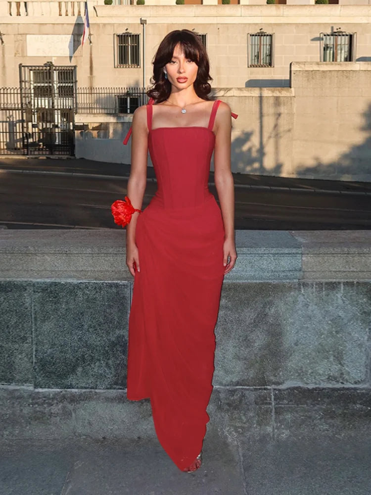 Woman in a red dress standing on steps with a building in the background