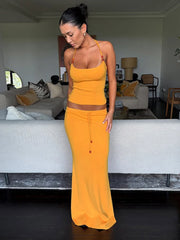 Woman in a yellow outfit standing in a living room.