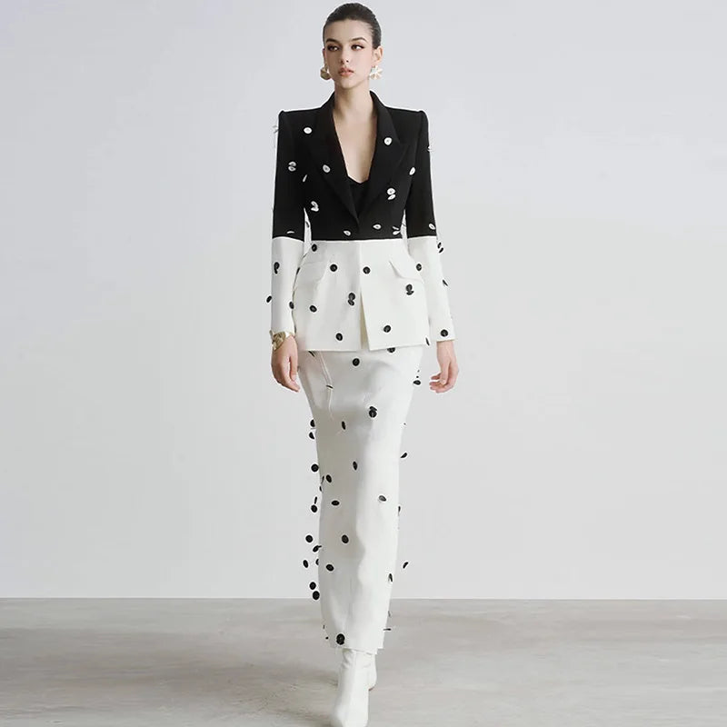 Woman wearing a black and white polka dot outfit on a plain background