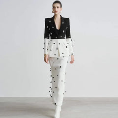 Woman wearing a black and white polka dot outfit on a plain background