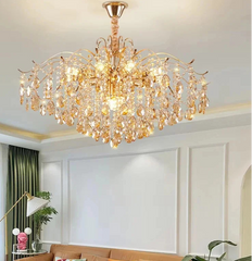 Gold chandelier hanging in a room with a couch and decorative items.