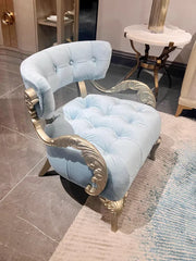 Light blue armchair with gold accents in a room setting