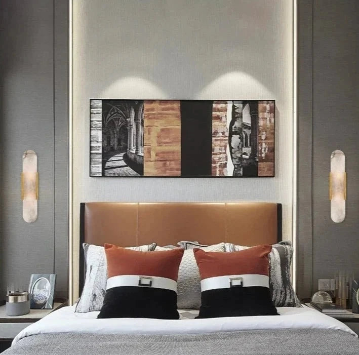 A luxurious hotel bedroom featuring a pair of marble wall sconces, creating a relaxing and sophisticated ambiance.M