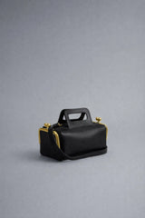 Black handbag with gold accents on a gray background