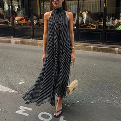 Woman in a black and white patterned dress walking on a street.