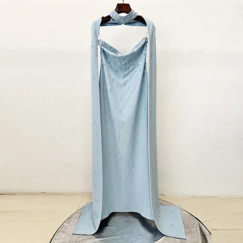 Strapless long gown with diamond embellishments and detachable cape displayed.
