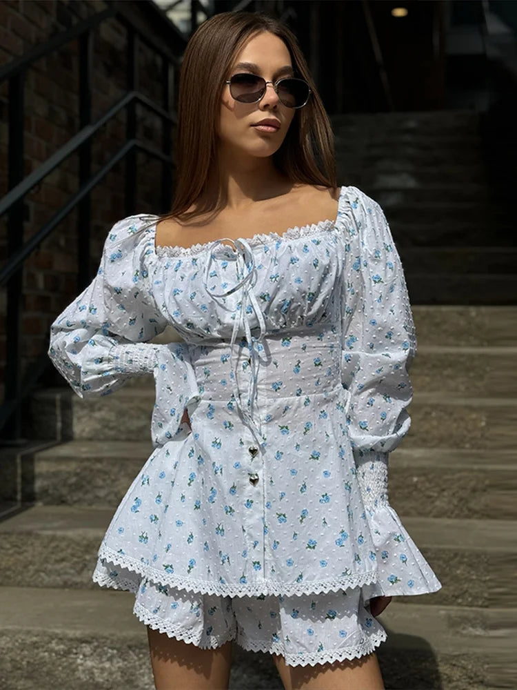 Woman wearing a white floral dress with puffed sleeves in an outdoor setting.