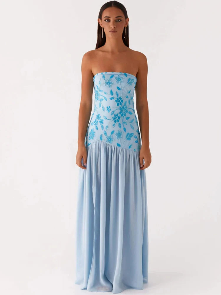 Woman wearing a strapless blue floral dress on a white background