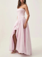 Woman wearing a strapless pink dress with a high-low hem on a white background