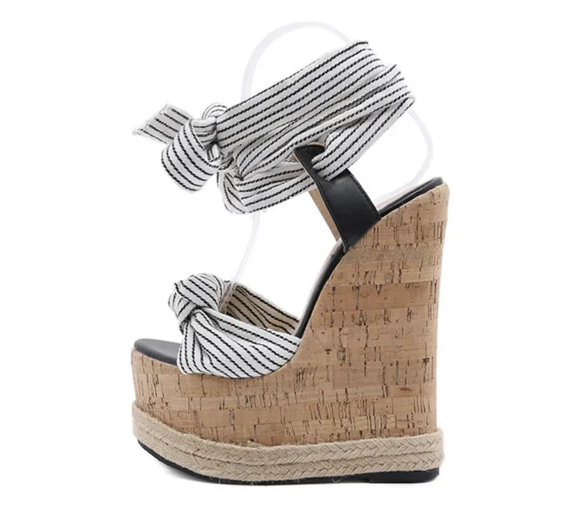 Wedge sandal with cork wedge and striped ankle strap on a white background
