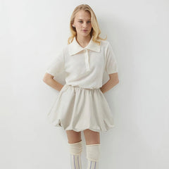 Woman wearing a white outfit with a plain background