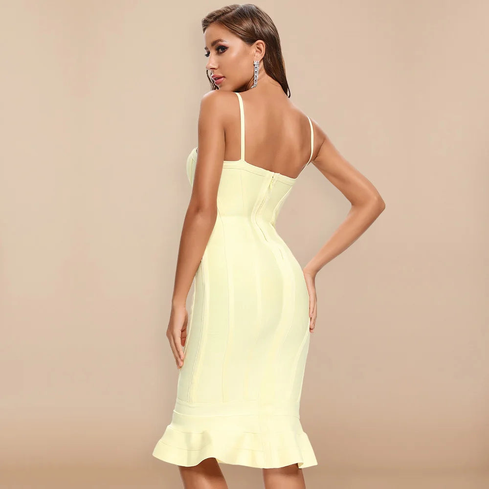 Woman wearing a light yellow dress with thin straps on a beige background