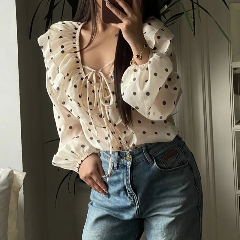 Person wearing a polka dot blouse and jeans indoors