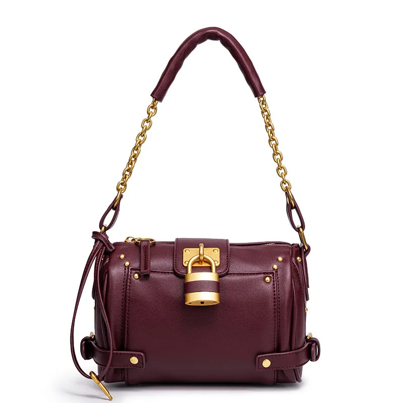 Burgundy structured leather bag with gold lock detail and chain strap