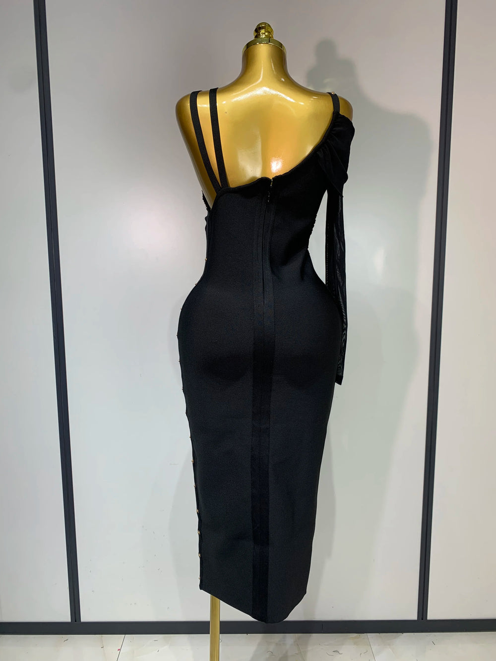 A black jumpsuit on a mannequin against a white background