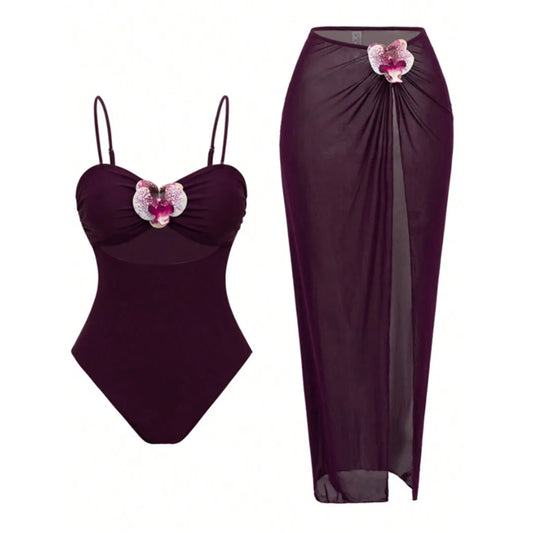 Wine red one-piece swimsuit with adjustable straps and cutout, paired with a high-slit sarong skirt featuring floral applique.