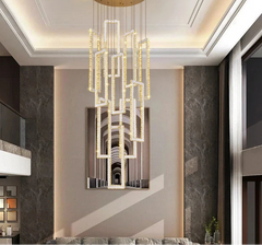 Modern chandelier in a stylish interior setting with gray walls and a painting.