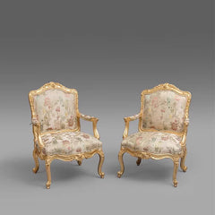 Pair of ornate chairs with floral upholstery on a gray background