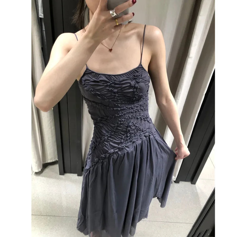 Model adjusting the hem of a ruched bodice asymmetrical hem spaghetti strap dress