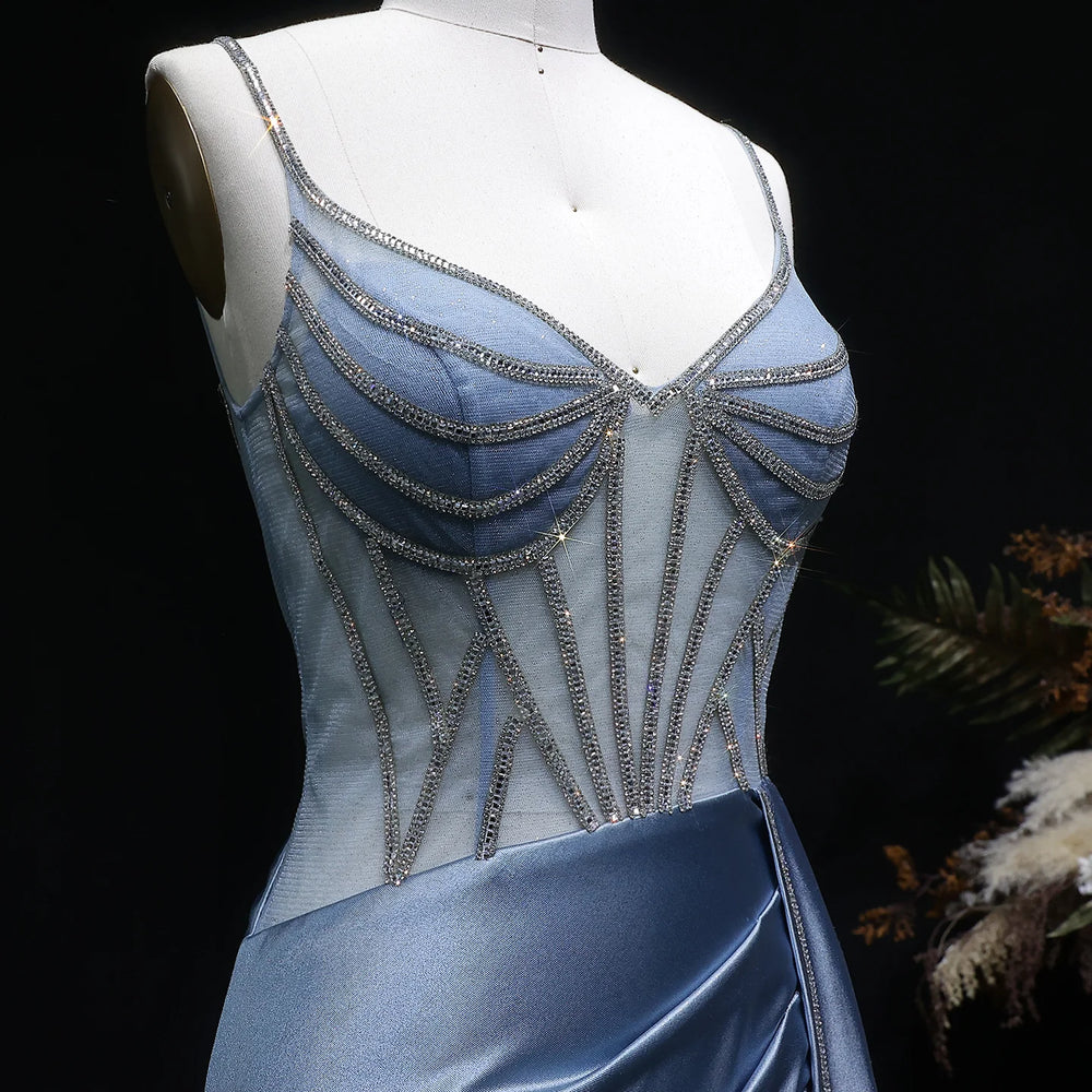 Blue evening gown with intricate beading on a mannequin against a dark background